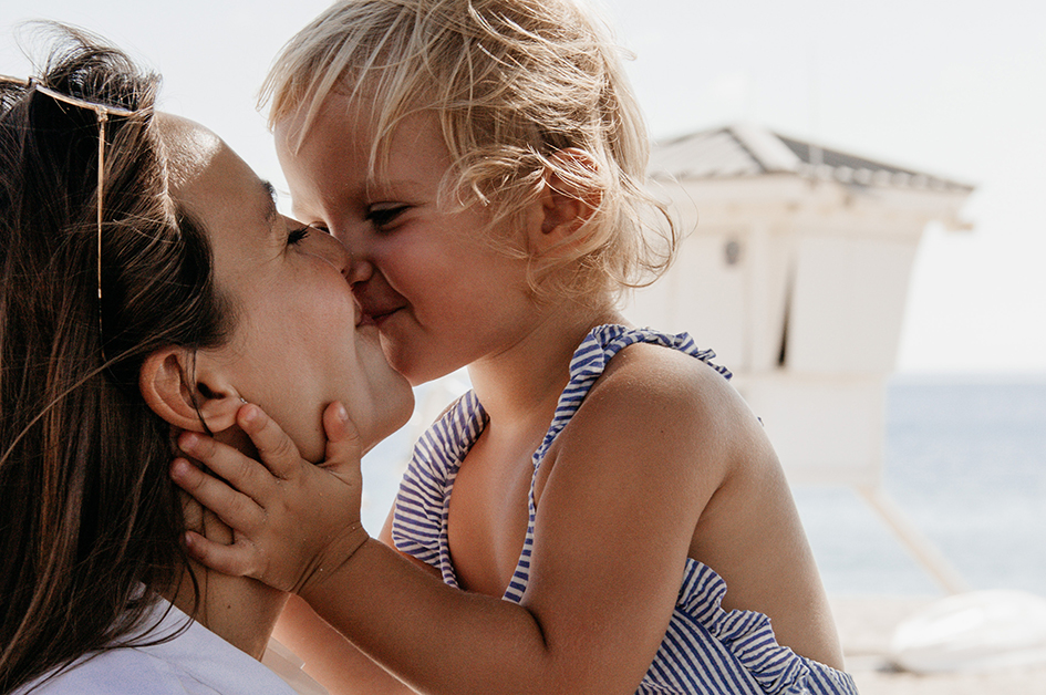 Foto de una madre besando a su hija pequeña para el post: ¿Buscas ideas para regalar un perfume el Día de la Madre? ¡Aquí tienes inspiración!